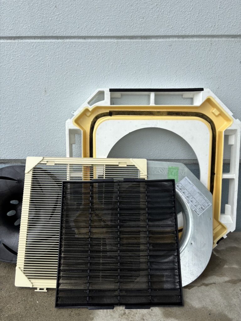 取り外した天井カセット形エアコンのパネルとフィルター
