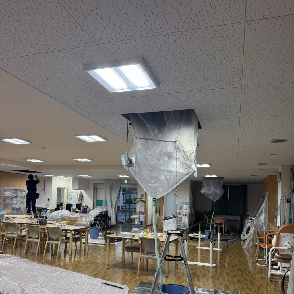 施設の食堂で天井カセット形エアコンを洗浄している様子
