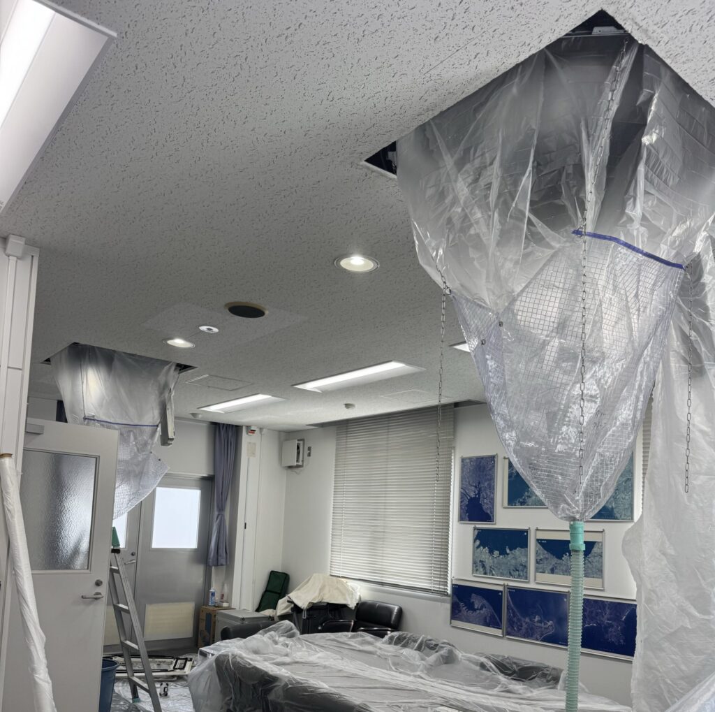 室内を養生して天井カセット形エアコンを洗浄している様子