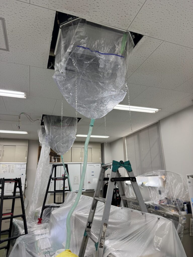 机や床をシートで養生して行うエアコン洗浄作業
