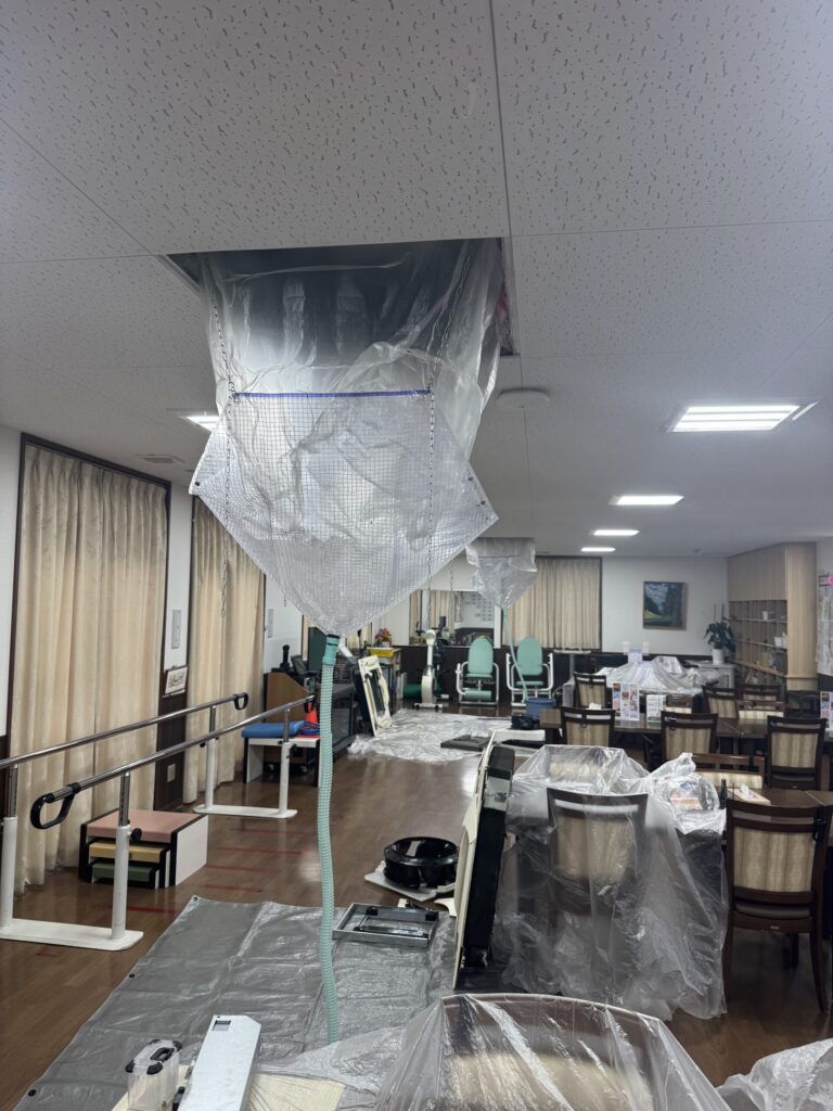 椅子や机をシートで養生して行う施設のエアコン洗浄